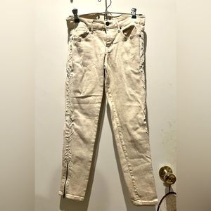 Off-white jeans with tribal print along each side and small zipper by each ankle